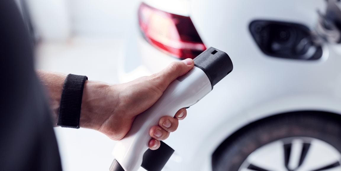 Man holding an electric car charger